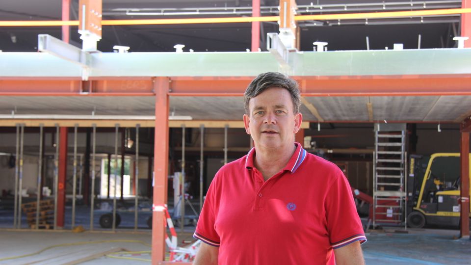 Eigenaar Nicky Broos in een rode polo poseert op de bouwplaats van het nieuwe Playdôme