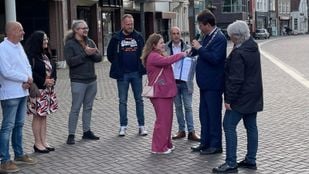Ginger van den Oever biedt de petitie 'Bouw geen AZC in Heerle' aan aan burgemeester Han van Midden en wethouder Klaar Koenraad op de markt in Roosendaal