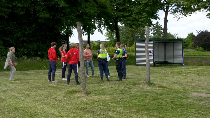 Op de speelplaats staan houten doelpalen een staat een JOP.
