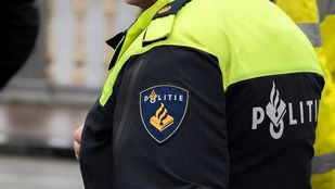 Close-up van de schouder van een agent met politie-embleem op de zijkant van de mouw.