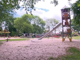 Overzichtsfoto van speeltoestellen op Speeltuin Vrouwenhof met op de voorgrond een glijbaan