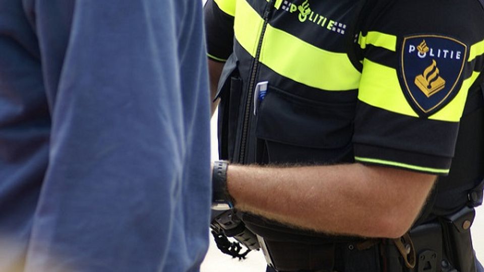 Close up van een agent die iemand de handboeien omdoet