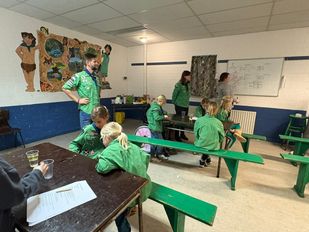 Lars Huiskens geeft de groep welpen uitleg over een proef.