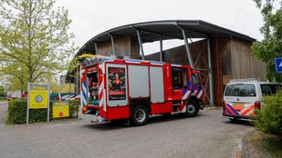 Branweerwagen en politiebusje staan voor de leveranciersingang van bouwmarkt