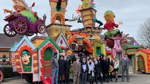 Verklede leden van bouwclub Hoevekestijn poseren voor hun felgekleurde carnavalswagen