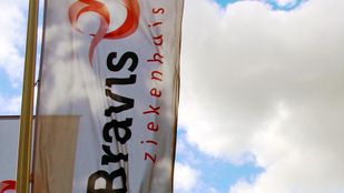 Witte banner met zwarte en rode tekst 'Bravis ziekenhuis' tegen een blauwe lucht en witte wolken