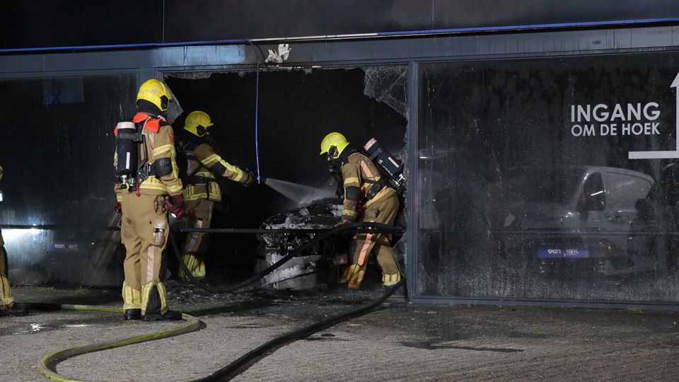 Auto in bedrijfspand vat vlam, brandweer schaalt groots op