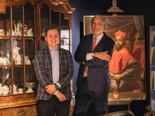 Bram Bouwens staat links met daarnaast Mark Haasnoot met achter hen een kast vol antiek porselein en een antiek portretschilderij