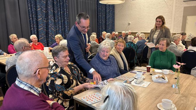 Burgemeester Adriaansen deelt prijs uit tijdens Denk Vooruit Bingo.