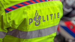 Logo van politie op rug van fluoriserend geel hesje