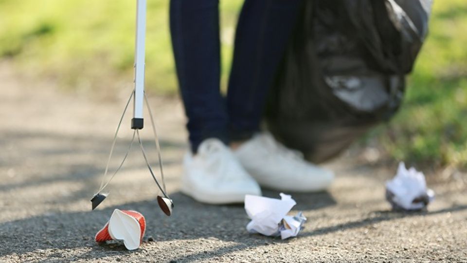 Close up van grijpstok waarmee zwerfafval wordt opgeraapt