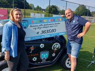 Leon Oomen en Sandra Jongenelen van voetbalvereniging SJO De Markiezaten in Bergen op Zoom staan naast een grote kartonnen cheque ter waarde van €3635,60