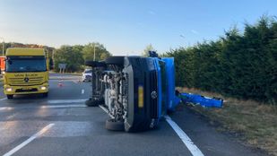 Gele bergingswagen staat naast een blauwe bestelbus die op z'n kant ligt
