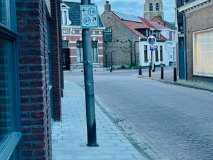 De nieuwe lantaarnpalen staan midden op de smalle stoep.