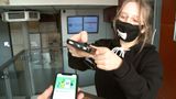 Vrijwilliger met mondkapje controleert toegangskaart op smartphone van bezoeker
