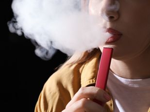 Jonge vrouw gebruikt een vape