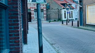 De nieuwe lantaarnpalen staan midden op de smalle stoep.