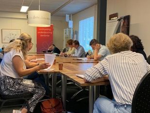 Groep mensen krijgt Nederlandse les in een Taalhuis van de Bibliotheek West-Brabant