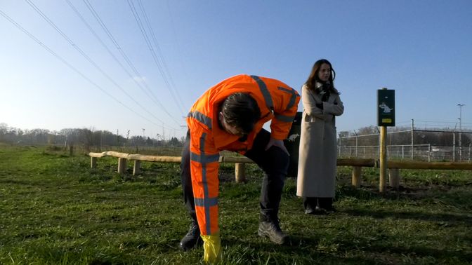 Wethouder Melisse ruimt de uitwerpselen van een hond op met de nieuwe zakjes.