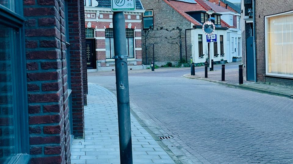 De nieuwe lantaarnpalen staan midden op de smalle stoep.