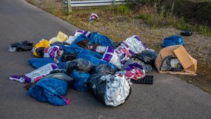 Stapel gedumpt afval met plastic potgrondzakken gevuld met oude potgrond en zwarte plantentrays