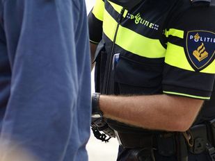 Close up van een agent die iemand de handboeien omdoet