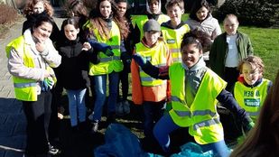 Kinderen van basisschool Zilverlinde in Roosendaal poseren in hun fluoriscerende hesjes met hun zwerfafvalgereedschap