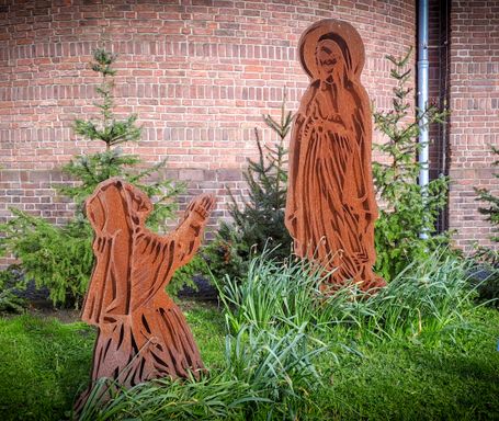 Een kunstwerk naast de Lourdeskerk, verbeeldt de verschijning van Maria aan Bernadette