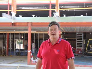 Eigenaar Nicky Broos in een rode polo poseert op de bouwplaats van het nieuwe Playdôme