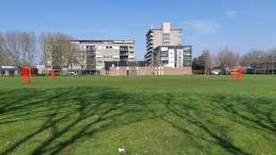 Foto van de voormalige kerk De Goede Herder in de wijk Langdonk met op de voorgrond het grasveld.