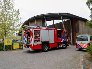 Branweerwagen en politiebusje staan voor de leveranciersingang van bouwmarkt