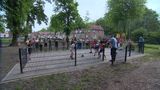 Tientallen kinderen staan op en rond een met hekken omringd voetbalcourt