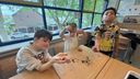 Alex, Jurre en Mason houden hun gevonden worm omhoog (foto: ZuidWest Update)