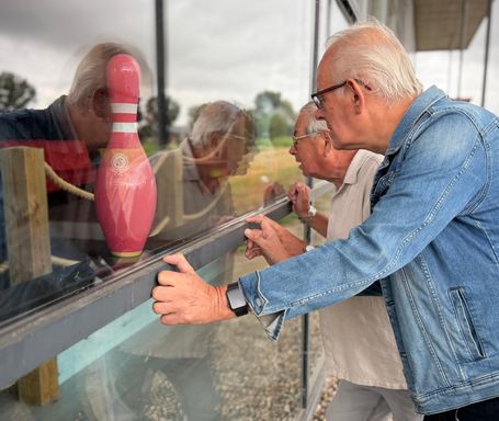 Secretaris Hanjo van den Wijngaart en voorzitter Ad van Zitteren kijken naar binnen bij de gesloten bowlingbaan in Tholen.