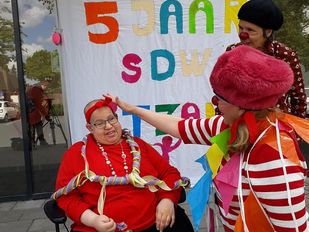 Clowns hangen slingers om de nek van Roseline Bernadina