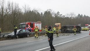 Ongeluk op de snelweg met auto tegen de vangrail en een bestelbus op z'n kant midden op de weg met er omheen hulpverleners van politie en brandweer