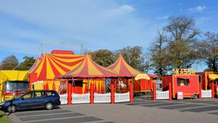 Rood-geel gestreepte kermistent, -kassa en -wagens