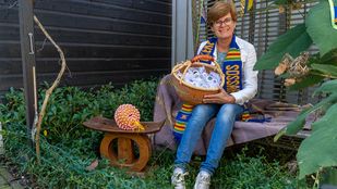 Annemieke de Bruijckere met naast haar een chief-stoel van haar vader, om haar nek een traditionele sjaal en in haar handen een mand vol goodies.