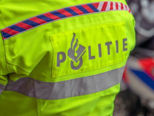 Close up van politielogo achter op fluoriscerend gele jas van een agent