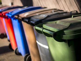Rijtje met afvalcontainers in verschillende kleuren