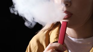 Jonge vrouw gebruikt een vape