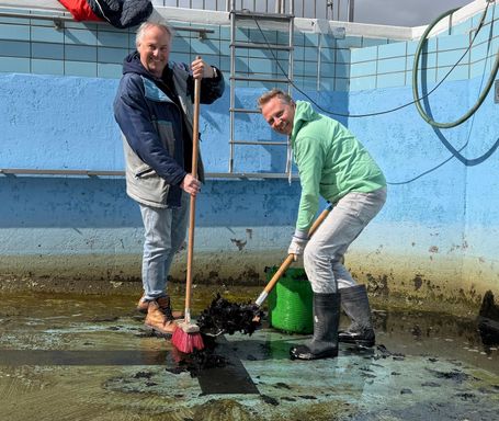 De vrijwiliigers zijn druk bezig met het schoonmaken van het zwembad in Willemstad.