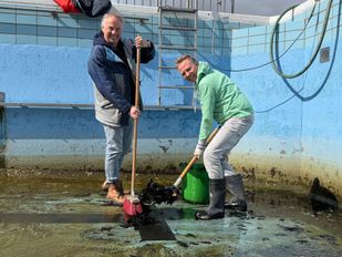 De vrijwiliigers zijn druk bezig met het schoonmaken van het zwembad in Willemstad.