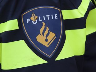 Close-up van een politie-embleem op gele reflecterende strepen op de mouw van een politie-uniform