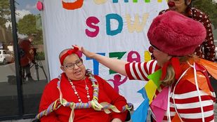 Clowns hangen slingers om de nek van Roseline Bernadina