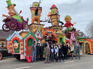 Verklede leden van bouwclub Hoevekestijn poseren voor hun felgekleurde carnavalswagen