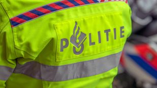 Close up van politielogo achter op fluoriscerend gele jas van een agent