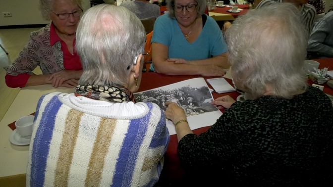 Onder het genot van een kopje koffie kijken de inwoners van Sprundel naar foto's van vroeger.