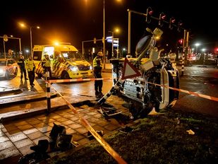 Auto op zijn kant tegen omver gereden verkeerslicht