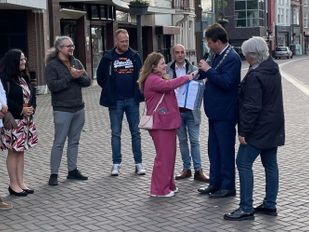 Ginger van den Oever biedt de petitie 'Bouw geen AZC in Heerle' aan aan burgemeester Han van Midden en wethouder Klaar Koenraad op de markt in Roosendaal